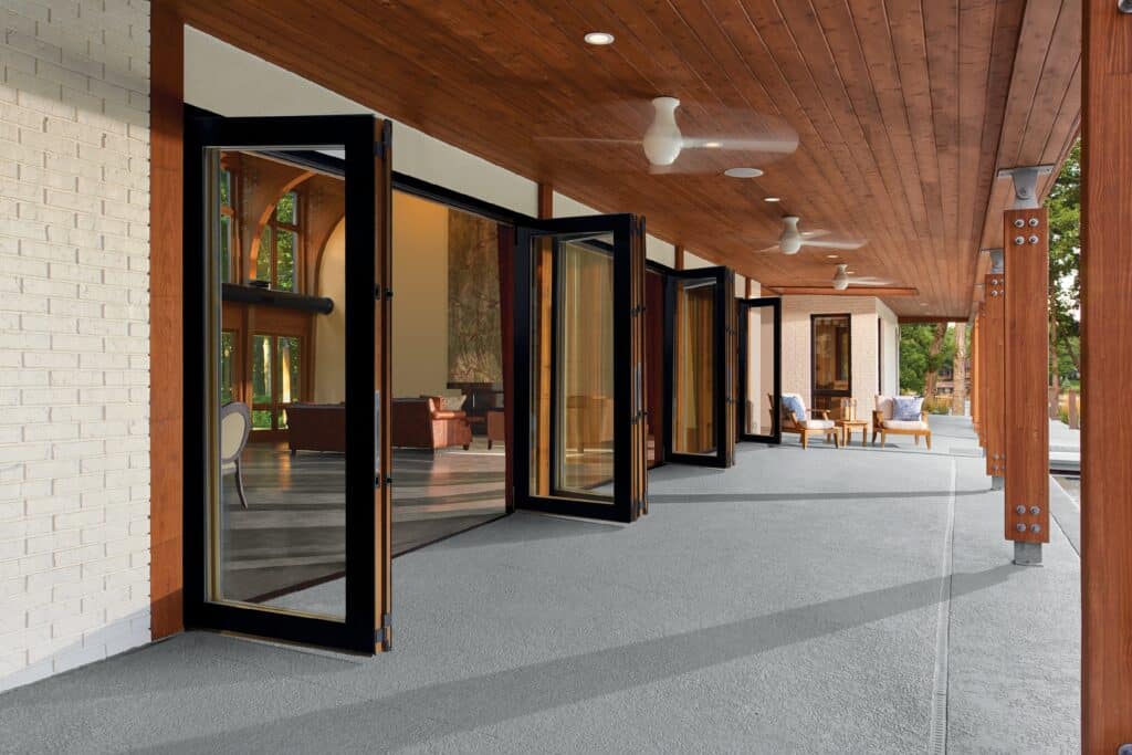 open bi-fold doors leading outside in a large dark brown wooden home, modern look