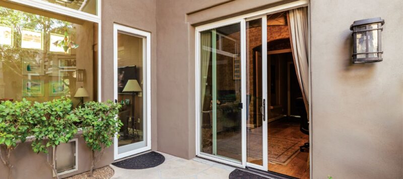 an open sliding glass patio door leading to the inside of a home