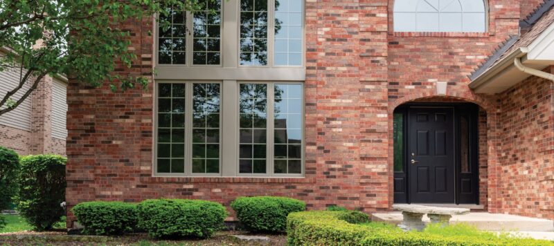 casement windows installed in the middle of a red brick wall of a home