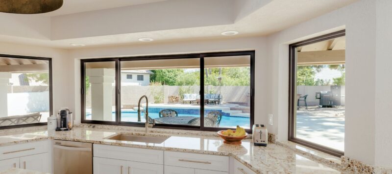 sliding windows in a kitchen that provide a view to the backyard