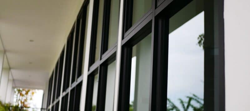 a wall of window panels with thick black frames on a commercial building